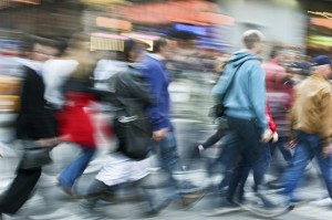 Suddig bil av människor i rörelse på trottoar